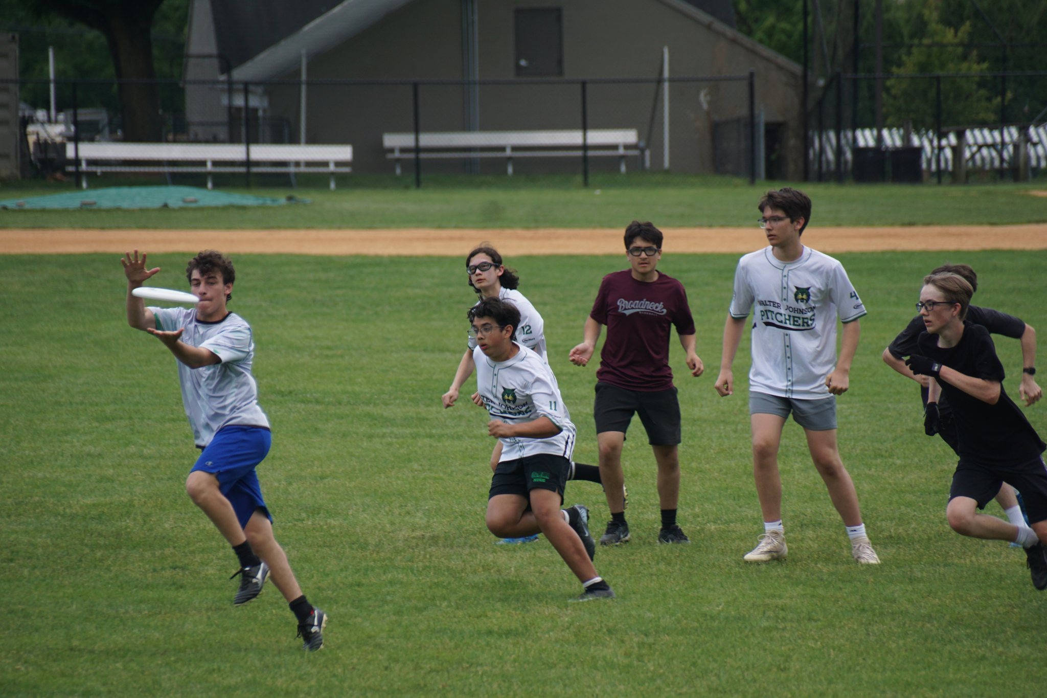 A Walter Johnson Pitchers player releasing a throw as defenders converge